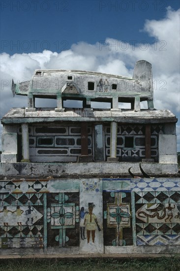 MADAGASCAR, Art, Part view of Mahafaly highly decorated tomb with carved effigy of aeroplane on roof.