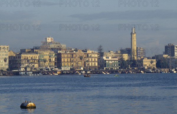 EGYPT, Port Said, City on coast where the Suez Canal meets the Mediterranean and founded in 1859 to house canal workers.  City and Suez Canal at dusk.