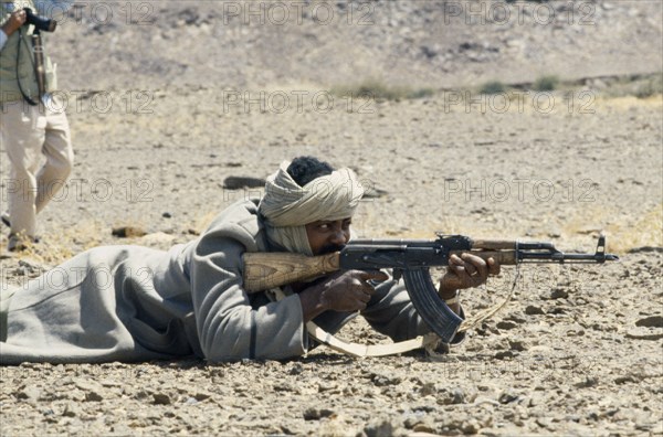 WESTERN SAHARA, SADR, Polisario Front soldier firing kalashnikov.  The Polisario Front is a Sahrawi movement working for the independence of Western Sahara.