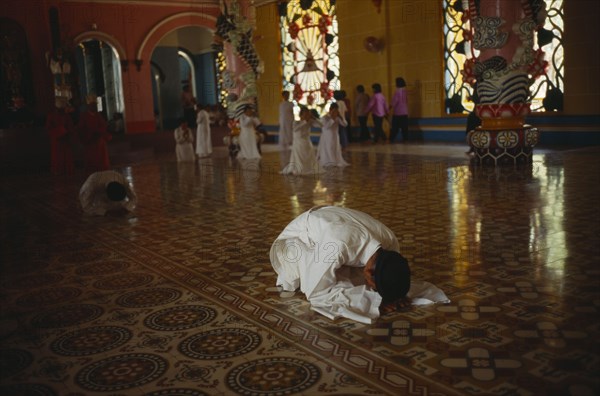 VIETNAM, Tay Ninh Province, Adherants at prayer in Cao Dai Temple