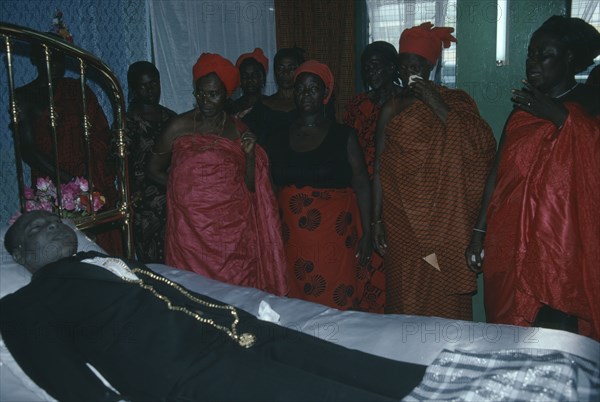 GHANA, Accra, Funeral of man from the Ga community.  His wife talks to her dead husband as is customary during the wake.