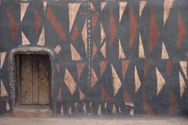 GHANA, North, Architecture, "Traditional mud architecture.  Walls painted with broken calabash pattern in red, black and white, an expression of ever useful.  Raised doorway keeps out water."
