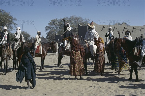 CHAD, People, Kanimbo men on horses holding swords above their heads as a welcoming to the Chiefs son
