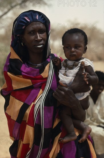 SUDAN, North Kordofan Prov., Tribal People, Portrait of Dar Hamid woman carrying child.  The Dar Hamid are nomadic Arab herders.