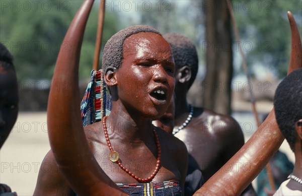 SUDAN, Tribal People, Dinka girl with red painted face at festival celebrating the return of cattle herds to the Toich or pastureland from swamps.