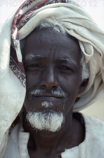 SUDAN, East, Tawawa Settlement, Head and shoulders portrait of Ethiopian refugee man with white beard and turban.