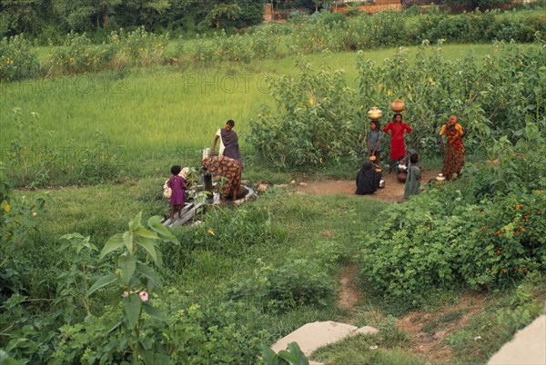 INDIA, Uttar Pradesh, Jhansi, Indian women drawing water from tubewell in rural area.