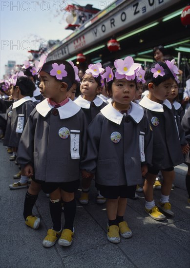 JAPAN, Honshu, Tokyo, Asakusa. Kannon Temple.Nursery school children dressed in uniforms and flower head bands for the Hara Matsuri Flower Festival celebrating buddhas Birthday.