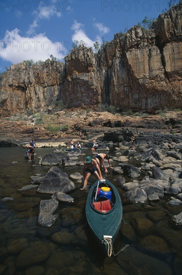AUSTRALIA, Northern Territory, Nitmiluk National Park, Katherine Gorge canoeists landing boats on the bank of the river which cuts through the sandstone plateau