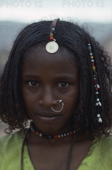 SUDAN, North East, Gadem Gafriet Camp, Portrait of Beni Amer Eritrean refugee girl wearing traditional jewellery.