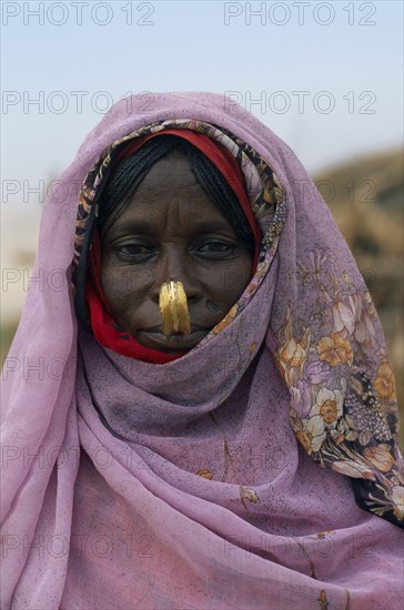 SUDAN, North East, Gadem Gafriet Camp, Head and shoulders portrait of Beni Amer nomad refugee woman.