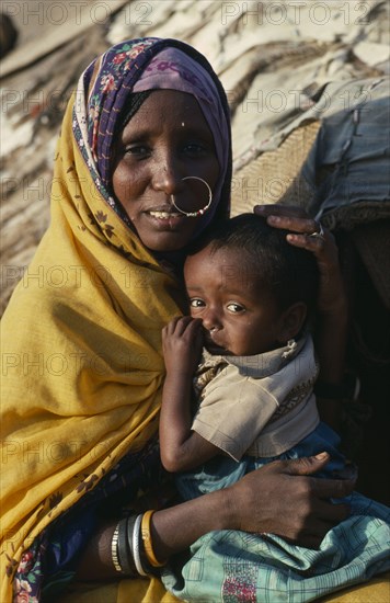 SUDAN, North East, Gadem Gafriet Camp, "Portrait of Beni Amer Beja nomad woman holding child, refugees from Eritrea."