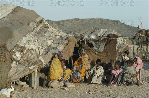 SUDAN, South Tokar, Gadem District, Beja nomad Beni Amer tribeswomen and children from Eritrea outside tent in refugee settlement.
