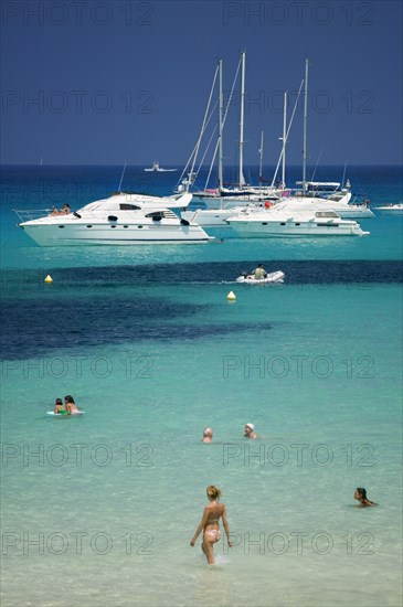 SPAIN, Balearic Islands, Ibiza, "Pleasure boats at Cala Saona, Formentera, with a few people swimming in the sea."