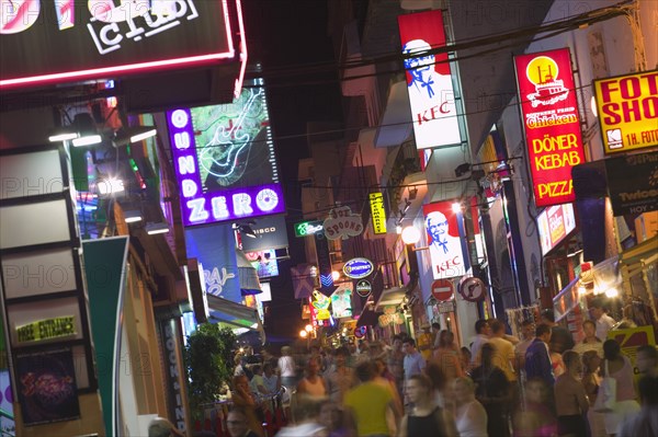 SPAIN, Balearic Islands, Ibiza, "Busy, crowded street in Sant Antonio with neon signs advertising food and clubs."