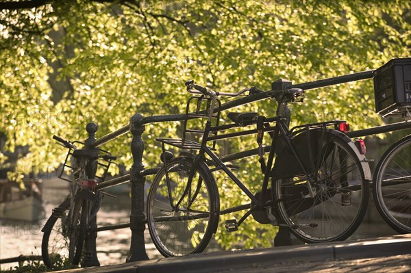 HOLLAND, North , Amsterdam, Bicycles leaning against railings on a city centre bridge.