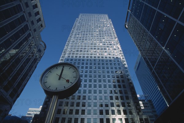ENGLAND, London, Canary Wharf. View of the tower at 1 Canada Square with clock in the foreground.