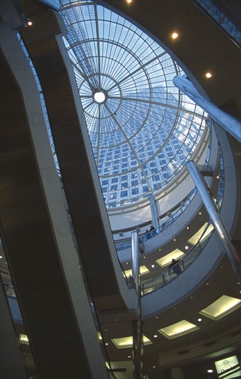 ENGLAND, London, Canary Wharf . Cabot Square Shopping area showing the escalators and glass atrium with the 1 Canada Square tower visible.