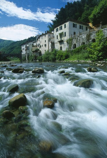 ITALY, Tuscany, Garfagnana, Bagni di Lucca.  Riverside buildings of historic spa town and bridge over the River Lima.