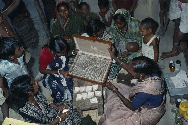 INDIA, West Bengal, "Woman doctor dispensing traditional Ayurvedic medicines at clinic.  Herbal medicine is combined with massage, manipulation, and advice on diet and lifestyle."