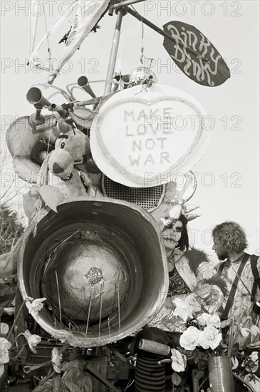 ENGLAND, Gloucestershire, Fairford, The Rinky Dink and peace protesters during an anti-war rally at RAF Fairford. Make love not war poster.