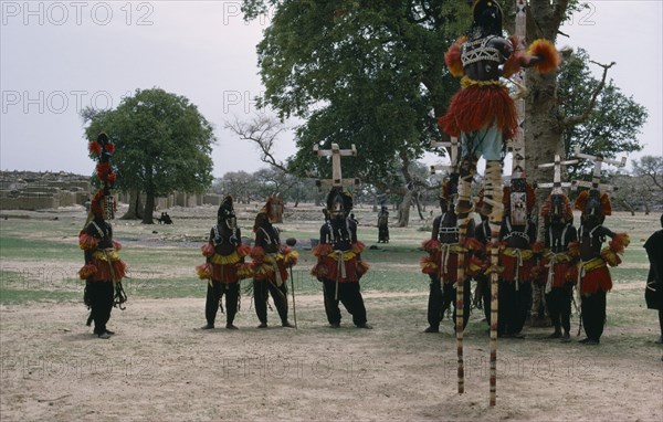 MALI, Ceremony, Dogon masked stilt dancer with others on ground below.