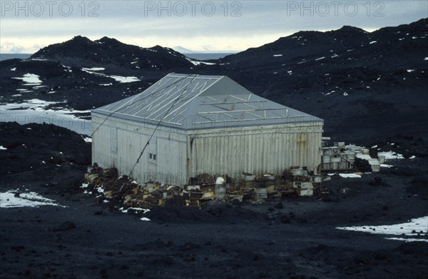 ANTARCTICA, Ross Island, "Shackleton’s Hut at Cape Royds,  with crates stacked around the sides of the weathered wooden building."