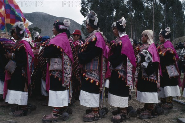 BOLIVIA, Sucre, Tarabuco, Phujllay yampara independence carnival celebrations.  Line of dancers wearing traditional costume including gallos or spurs attached to their sandals or ojotas.