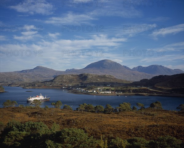 SCOTLAND, Highlands, Torridon, "Sheildaig Village with cruise ship, Hebridean Princess, in front of mountain. Upper Loch Torridon"