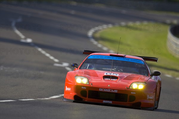 FRANCE, Le Mans, "Number 65 Red Prodrive Ferrari 550 Maranello race car with British flag on bonnet, exiting the Porsche Curves."