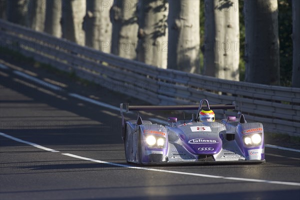 FRANCE, Le Mans, "Number 8 purple and silver Audi R8 race car with advertising and logos, exiting Tetre Rouge."