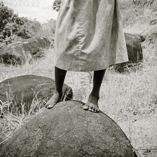 INDIA, Tamil Nadu, Near Vellamadam, A young Indian female orphan stands on a rock in a cobra-infested piece of farmland.
