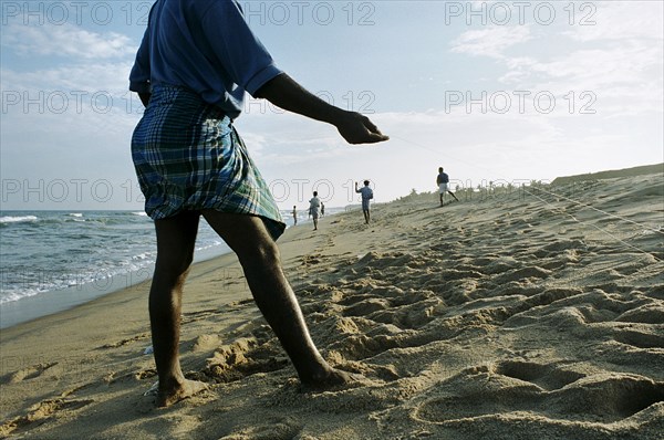 INDIA, Tamil Nadu, Auroville Beach, South Indian fishermen return to beach-casting 5 weeks after the Indian Ocean Tsunami that hit the coast on 26th December 2004.