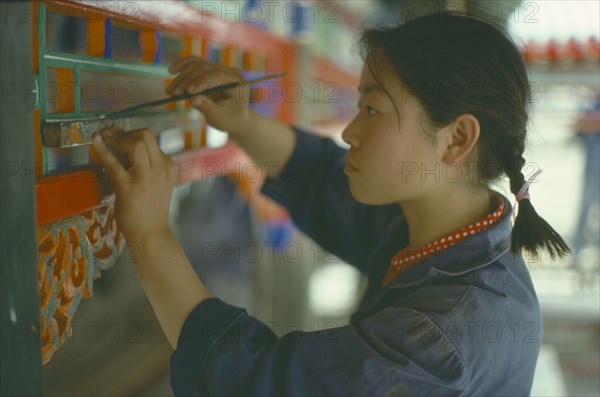 CHINA, Beijing, Young woman undertaking restoration work on the Summer Palace.