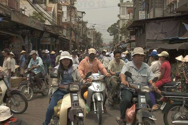 VIETNAM, South, Ho Chi Minh City, Busy traffic in downtown area with people riding motorbikes