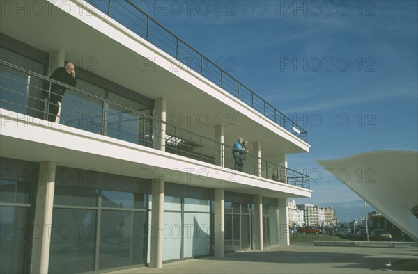 ENGLAND, East Sussex, Bexhill on Sea, De La Warr Pavilion. Exterior view of visitors on balcony terrace and corner of bandstand.