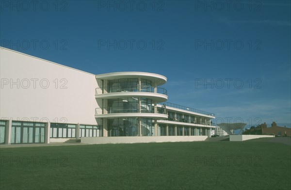 ENGLAND, East Sussex, Bexhill on Sea, De La Warr Pavilion. Exterior view over grass towards back entrance and staircase section.