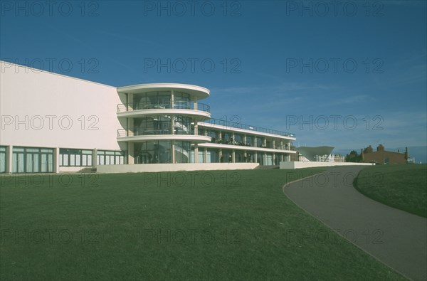 ENGLAND, East Sussex, Bexhill on Sea, De La Warr Pavilion. Exterior view over grass towards back entrance with staircase section and terracing.