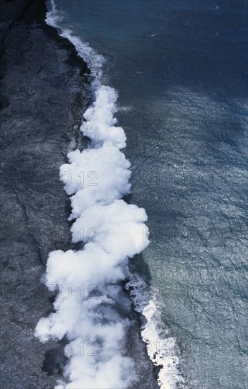USA, Hawaii, Big Island, Steam cloud rising where lava enters the sea on the south east Puna Coast near Kaimu.  It flows in tubes from the Pu’u O’o cinder cone inland.