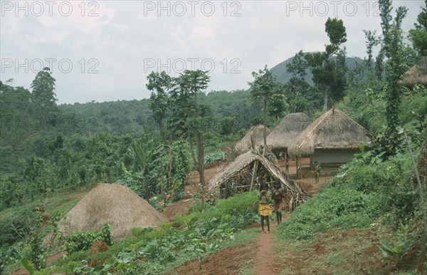 INDIA, Karnataka, Gudulur Hills, Children on a path leading to a tribal village surrounded by green forest and  vegetation.