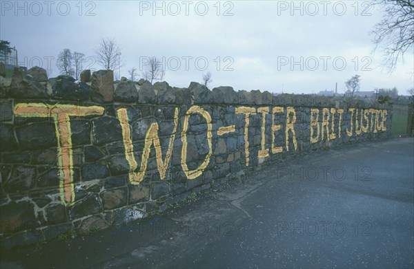 IRELAND, North, Belfast, Falls Road. Beechmount Area. Anti British grafitti on a wall saying Two Tier British Justice