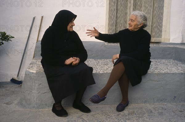 SPAIN, Andalucia, Two elderly ladies in conversation in village street.