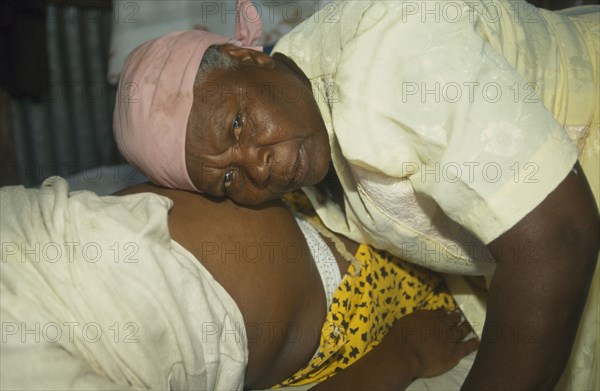 MAURITIUS, Rodrigues Island, Seventy year old traditional birth attendant listening to foetal heart.