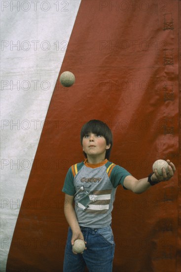 CHILDREN, Playing, Child juggling three balls.