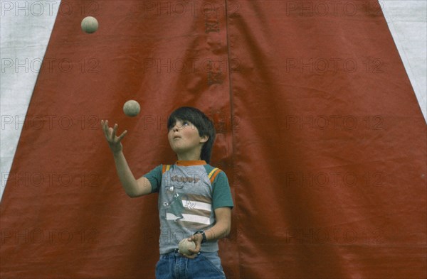 CHILDREN, Playing, Child juggling three balls.