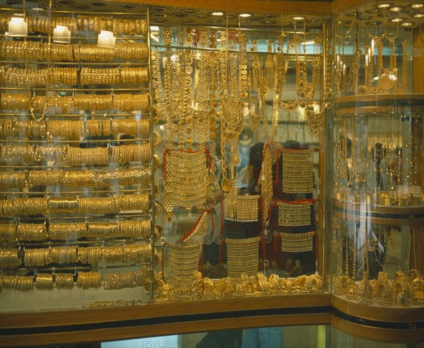 UAE, Dubai, Yellow Gold displayed in shop window. Different types of jewellery including necklaces and bracelets.