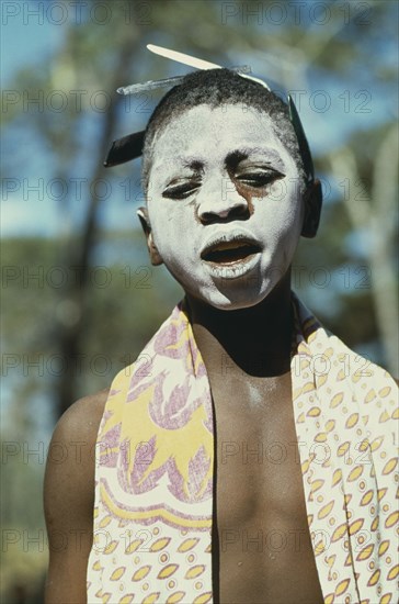 TANZANIA, Tribal People, Portrait of young girl with her face covered in ritual whitening for initiation ceremony held after her first menstruation.