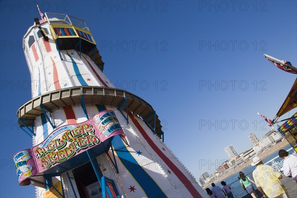 ENGLAND, East Sussex, Brighton, The Helter Skelter ride on Brighton Pier with tourists walking past and the city in the distance