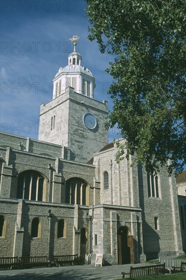 ENGLAND, Hampshire, Portsmouth, Old Portsmouth. High Street. The Cathedral of St Thomas  framed by tree branches.