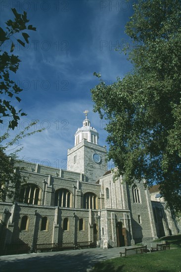 ENGLAND, Hampshire, Portsmouth, Old Portmouth. High Street. Cathedral of St Thomas framed by tree branches.